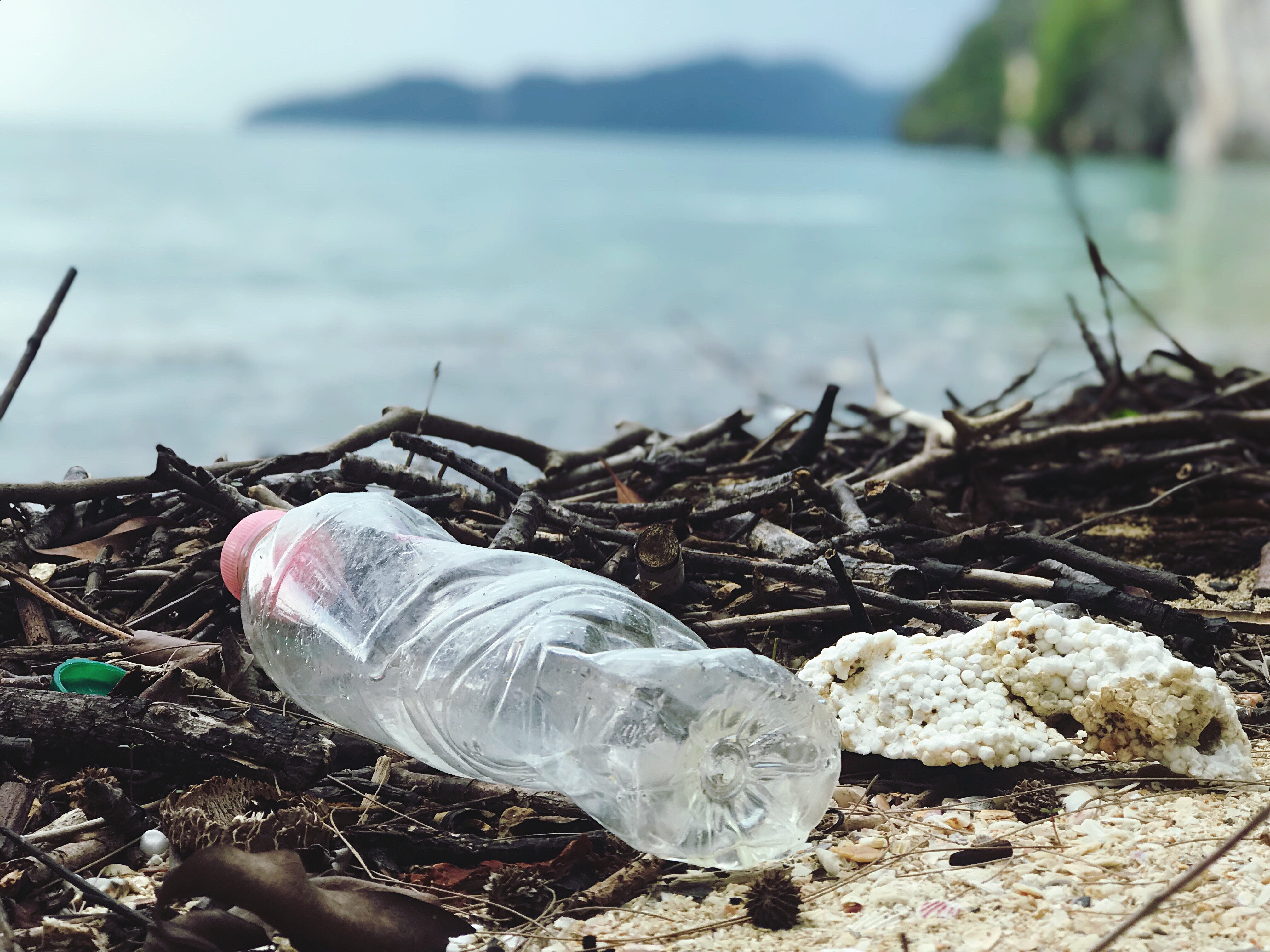 Discarded plastic bottle on a beach, highlighting environmental pollution.