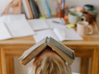 Student with book on face.