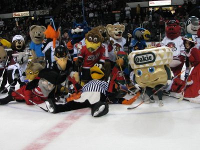 A group of sports mascots gathered on an ice hockey stadium.