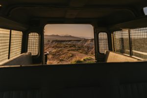 A mountain range seen from the back of a truck.