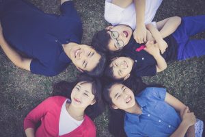 A family of five lying on the grass in a circle.