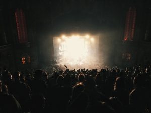 An audience watching a backlit stage.