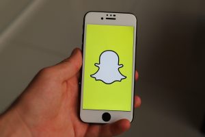 A phone with an illustration of Snapchat.