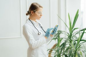 Doctor using a smartphone next to green plants.