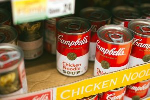 Campbells chicken noodle soup cans in a lot.