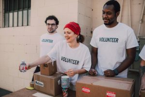 Three volunteers donating goods.