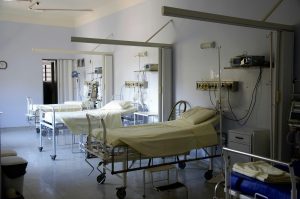 A row of white hospital beds in a hospital room.