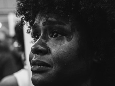 Close-up grayscale portrait capturing deep emotion on a woman's face.