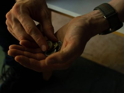 Close-up of hands counting coins, implying budgeting or financial planning.