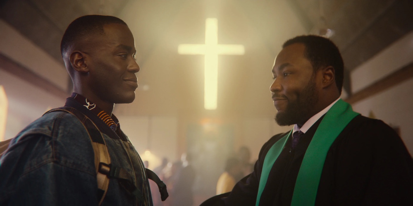 Still of Eric and Pastor Samuel from Sex Education. 