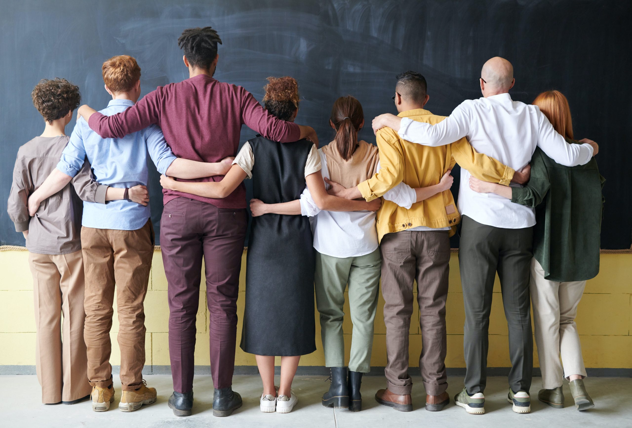 A line of people standing with their arms around each other.