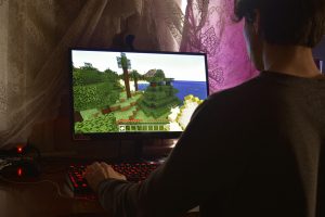 A person playing Minecraft in a dimly-lit room. 