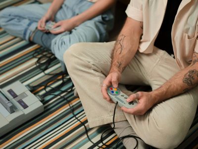 Two people playing a video game on a Super Nintendo Entertainment System.