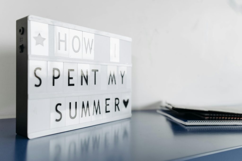 A white sign that says "How I spent my summer" in black text.