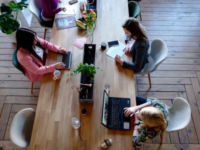 Three women working on computers, separately