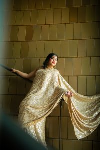 A solo picture of Ishita Singla wearing a gold saree by Avi Randhawa/ASR Made It