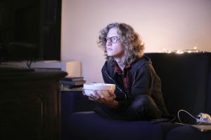 Person with a bowl of popcorn watching television