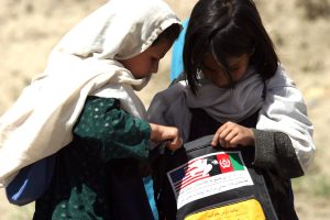 Surobi, Afghanistan (May 13, 2004) - Afghan children look through school supplies provided by U.S. Marines from Headquarters Company, 6th Marine Regiment. Marines and Sailors from the company frequently support security, stability and civil affairs operations in the region.