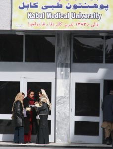 Three female students talking outside of Kabul Medical University.