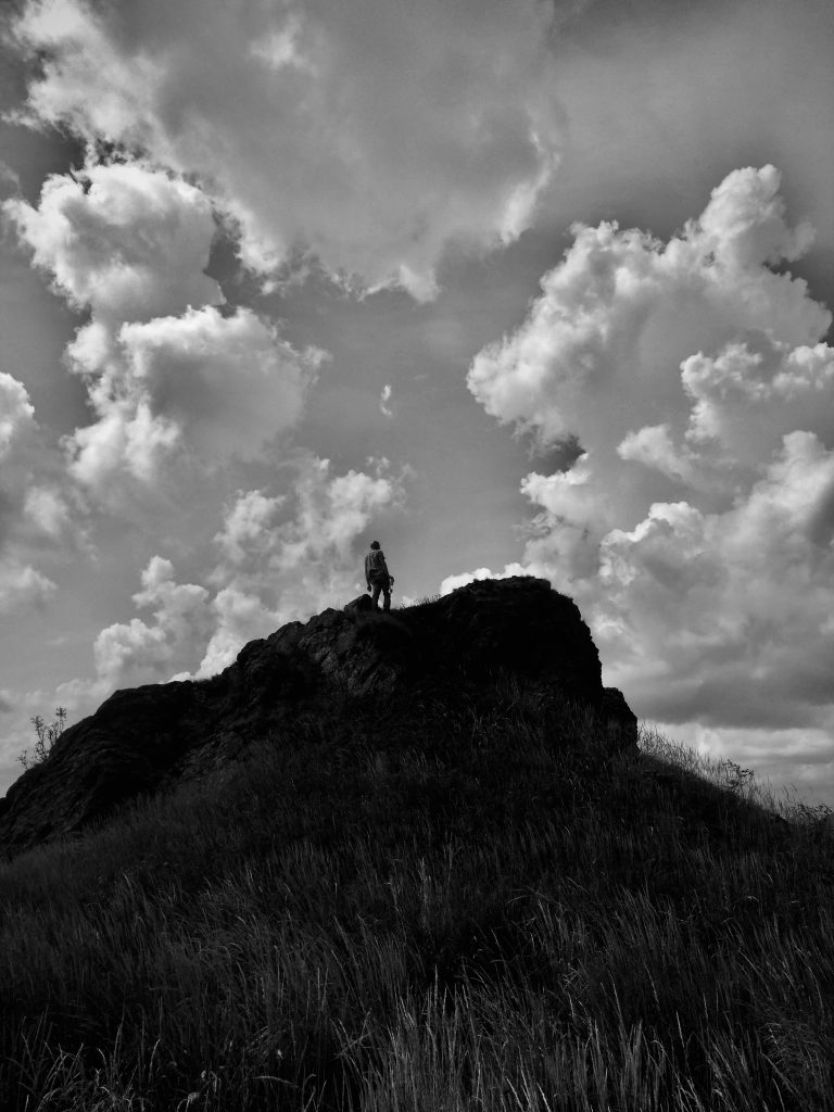 silhouette of a man atop a mountain