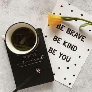 Notebook and paper with positive words.