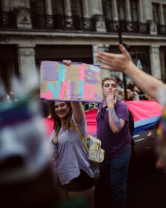 People at pride parade holding sign reading "Bi is valid".