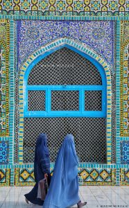 Two women in burqas walk past the Blue Mosque (Shrine of Hazrat Ali) in Mazar-i-Sharif, Afghanistan