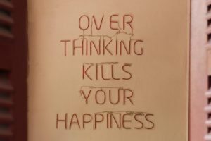 A sign reading "Overthinking kills your happiness".
