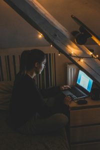 attic-workspace-image A girl in her dark room writing on her laptop.