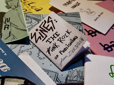 Pile of zines with the folded zine about this article centred in frame