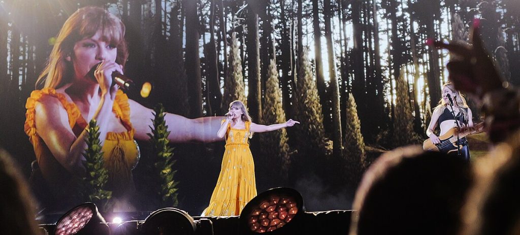 Photo of Taylor Swift performing in a yellow dress.