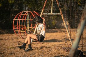 Girl getting off swing.