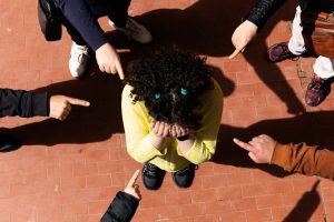 Girl being teased as people point fingers at her.