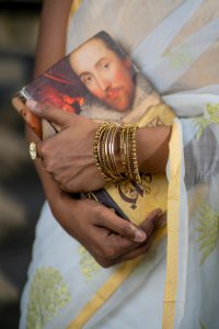 Photo of a woman's hands holding a book with Shakespeare on the cover.