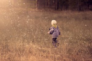Young child walking in tall grass