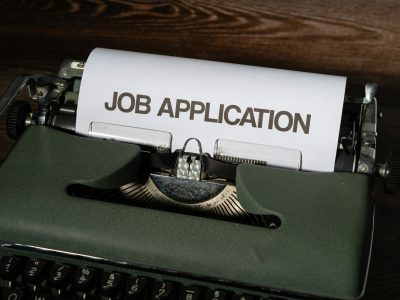 A type writer with the words "Job Applicaton" typed on white paper