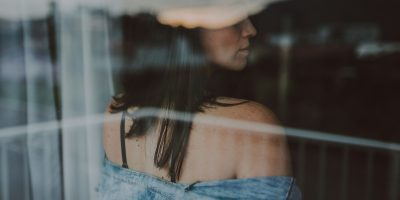 A woman looking back towards a window.