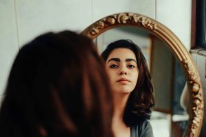 A woman looking at herself in the mirror.