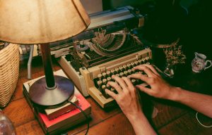 Person typing on typewriter